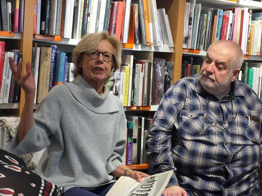 Ghislaine Dunant et Marc Pataud assis devant une bibliothèque. Ghislaine parle et Marc la regarde